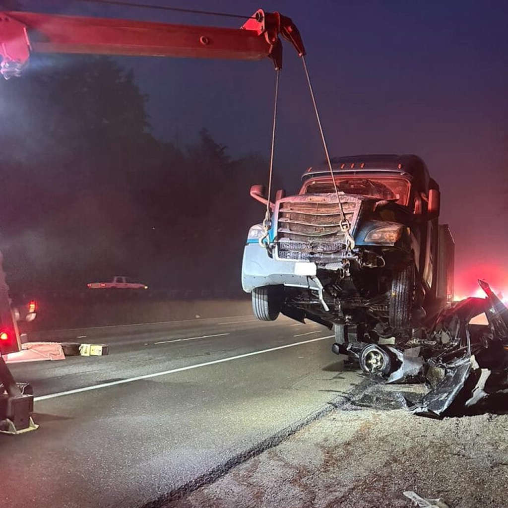 photo shows Big Wheel Wrecker Service wrecker towing a semi truck from an accident crash
