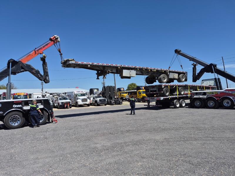 photo shows 2 Big Wheel Wrecker Service wreckers recovering a flat bed trailer